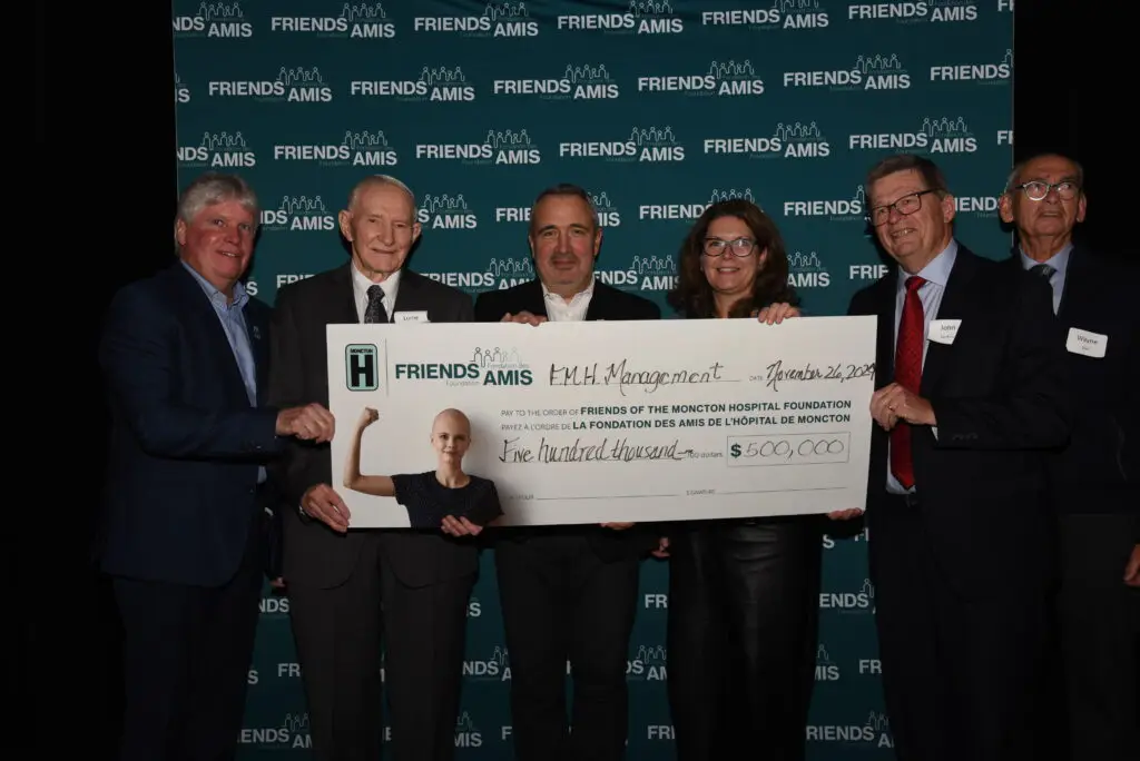 Group of people holding up large cheque at cheque presentation
