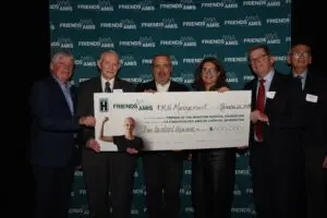 Group of people holding up large cheque at cheque presentation