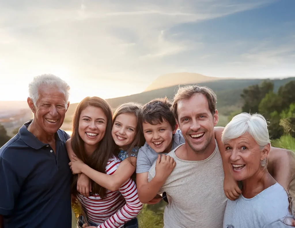 Multi generational family in a field smiling