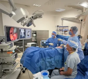 Group of Surgeons in OR looking at monitors performing laparoscopic procedure